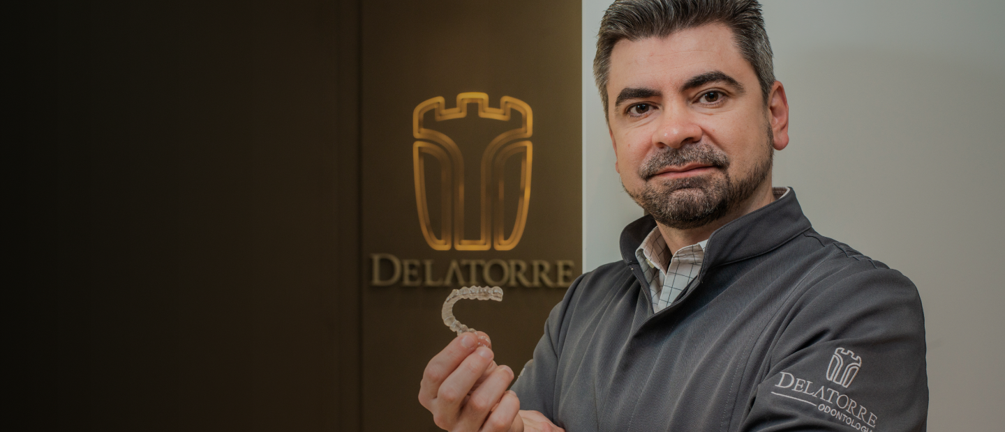 Dr. Laydir Delatorre segurando um alinhador Invisalign